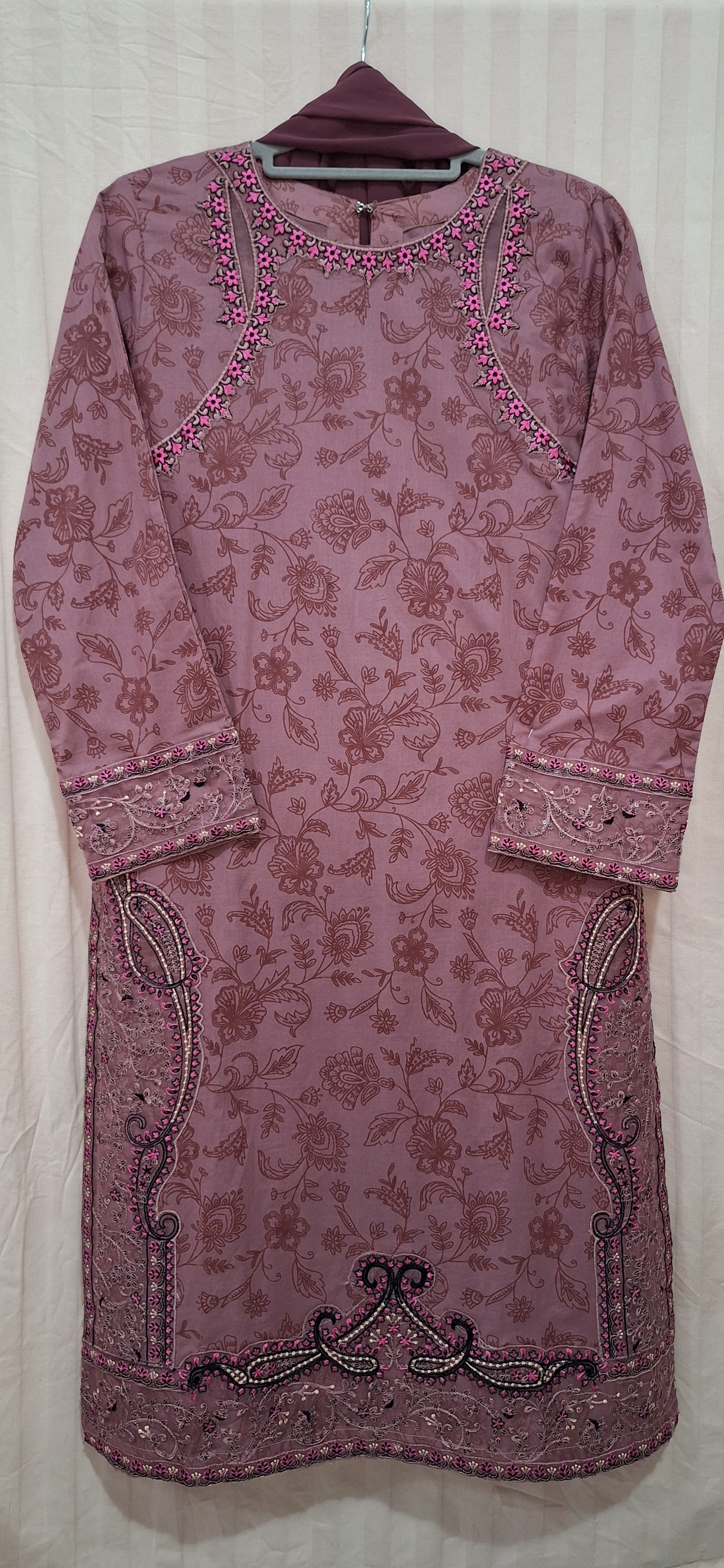 A mauve-colored long-sleeve kurta with an allover floral jacquard pattern, featuring embroidered details along the neckline, cuffs, and hem.